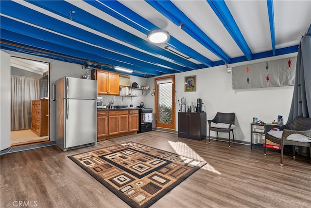 kitchen featuring gas stove, dark hardwood / wood-style floors, sink, and stainless steel refrigerator