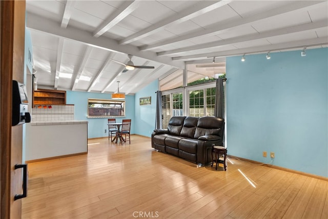 living room with light hardwood / wood-style flooring and lofted ceiling with beams