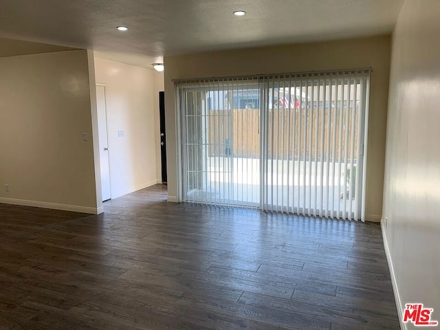 spare room featuring dark hardwood / wood-style floors and a healthy amount of sunlight