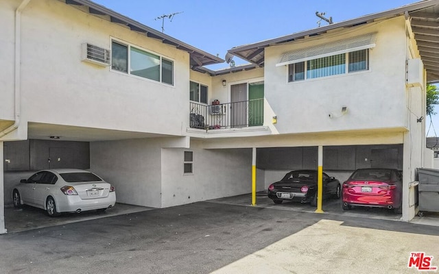 exterior space featuring a wall unit AC and a carport