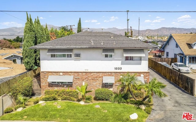 view of side of home with a mountain view and a yard