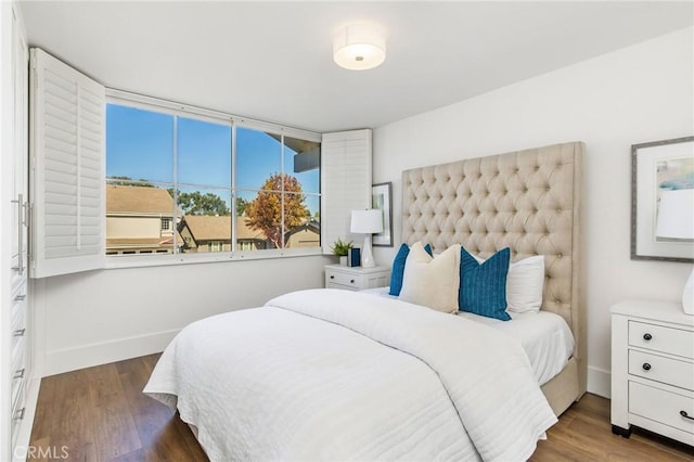 bedroom with dark hardwood / wood-style floors