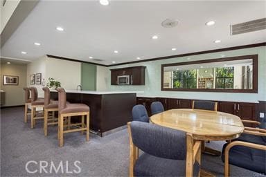 dining room featuring ornamental molding and carpet