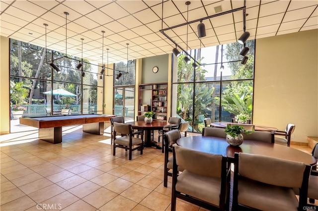 tiled dining room with a wall of windows and billiards