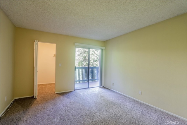 spare room with a textured ceiling and carpet floors