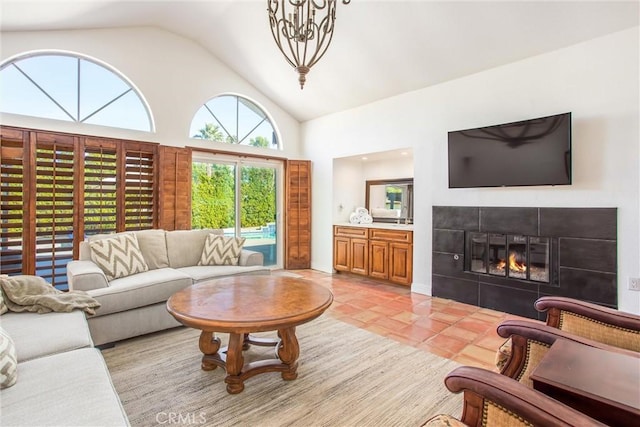 living room with high vaulted ceiling, light tile patterned floors, and a tile fireplace