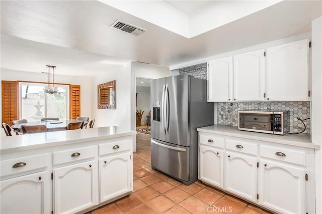 kitchen featuring backsplash, pendant lighting, white cabinets, and stainless steel appliances