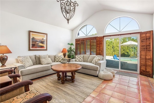 tiled living room featuring a chandelier and high vaulted ceiling