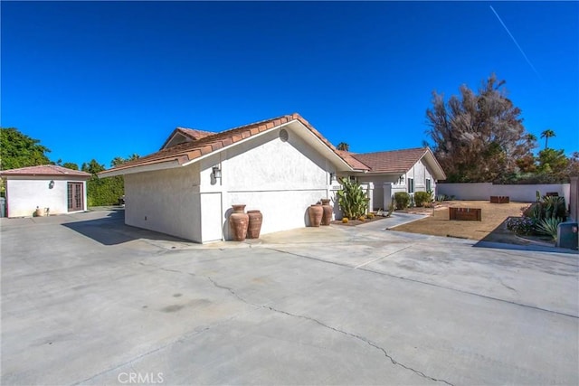 view of side of property featuring a patio and an outdoor structure