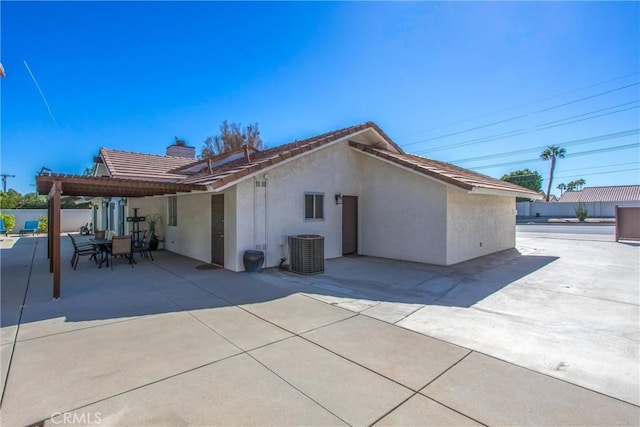 back of property featuring a pergola, cooling unit, and a patio area