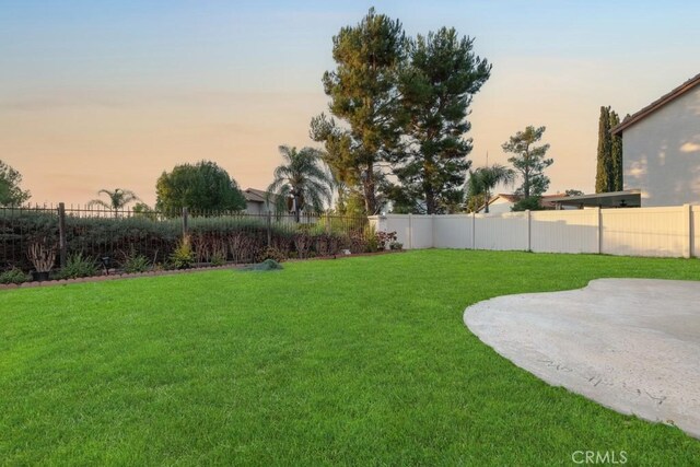 yard at dusk featuring a patio area