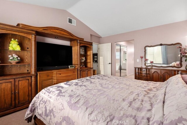 carpeted bedroom featuring lofted ceiling, connected bathroom, and a closet