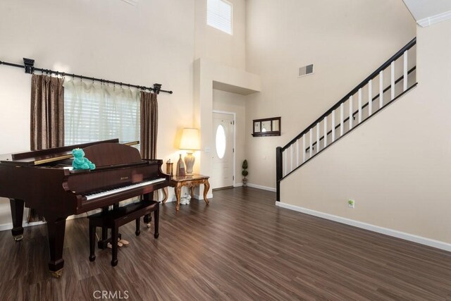 misc room featuring dark wood-type flooring and a high ceiling