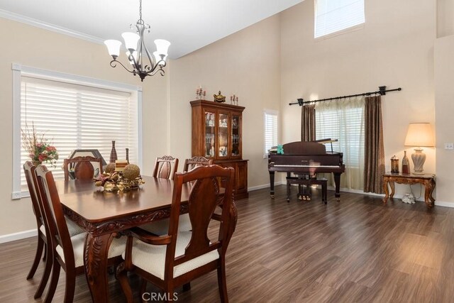 dining area with a chandelier, a wealth of natural light, dark wood-type flooring, and ornamental molding