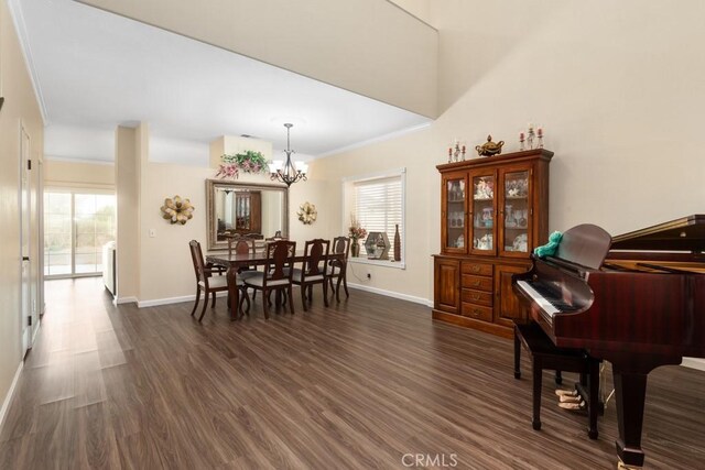 dining room with a notable chandelier, plenty of natural light, dark hardwood / wood-style flooring, and ornamental molding