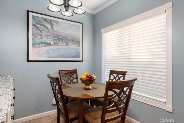 tiled dining area with a notable chandelier and crown molding