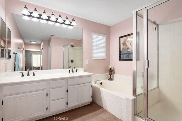 bathroom with vanity and shower with separate bathtub