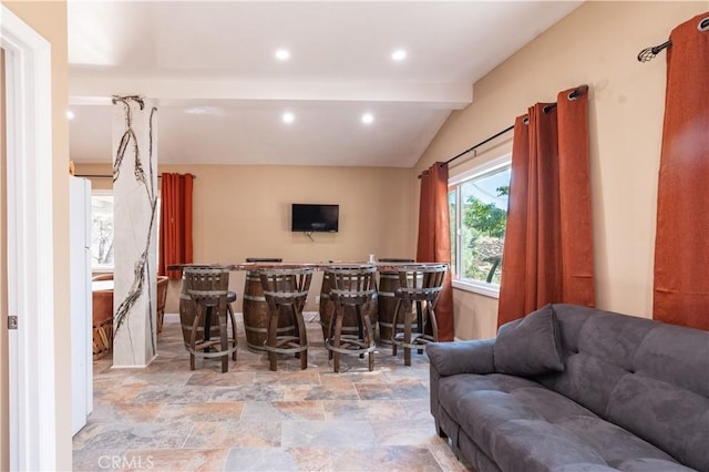 interior space featuring vaulted ceiling with beams and indoor bar