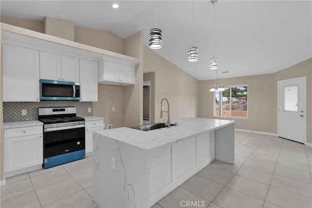 kitchen with stainless steel appliances, white cabinets, a center island with sink, and sink