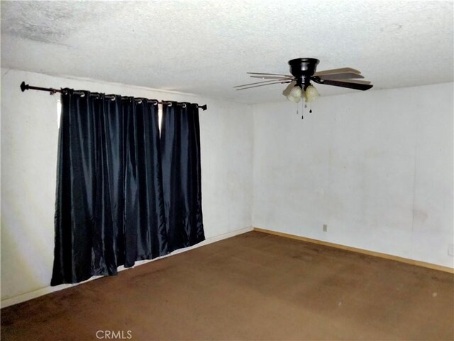 carpeted spare room featuring ceiling fan and a textured ceiling