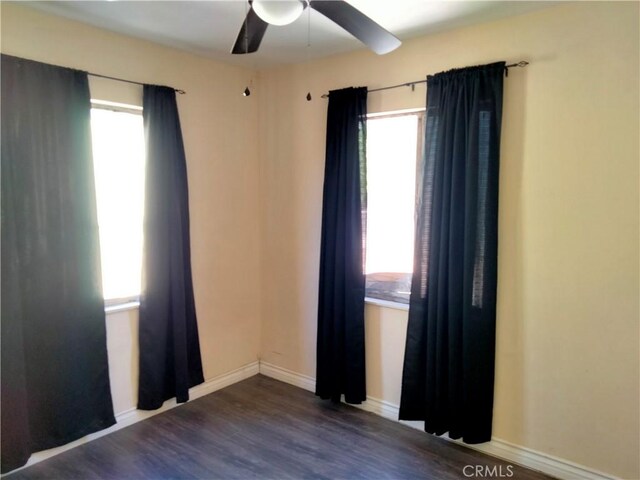 unfurnished room with ceiling fan and dark hardwood / wood-style flooring