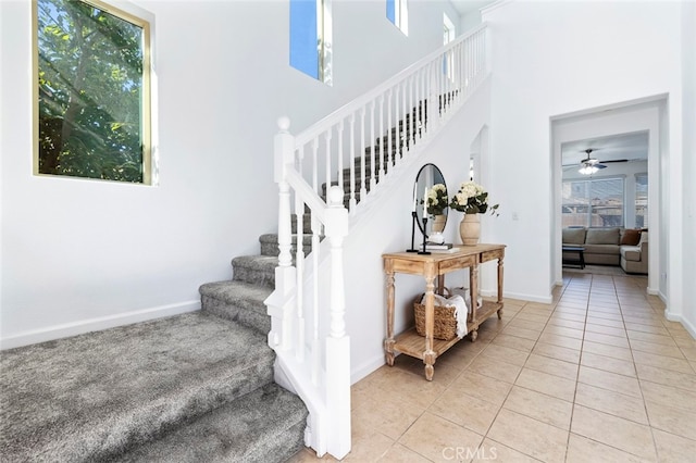 stairway featuring ceiling fan and tile patterned flooring