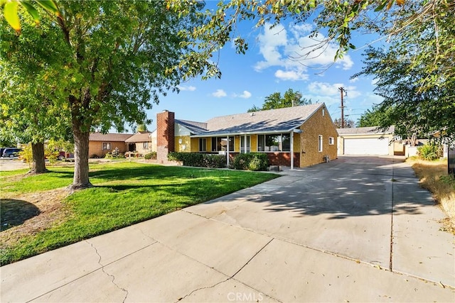 view of front of home with an outbuilding, a front lawn, and a garage