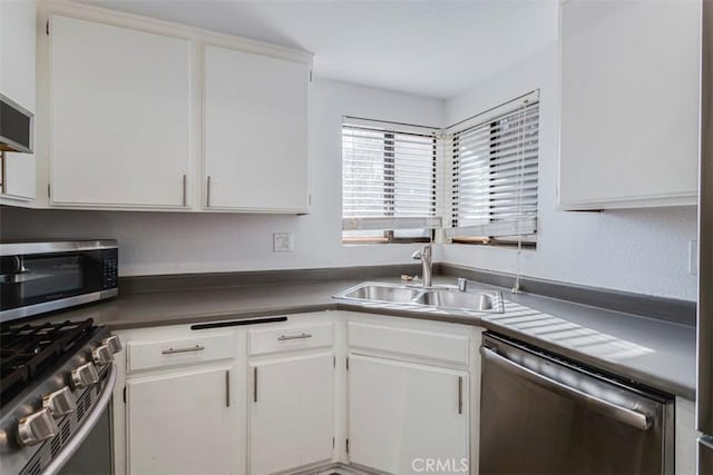 kitchen featuring appliances with stainless steel finishes, white cabinetry, and sink