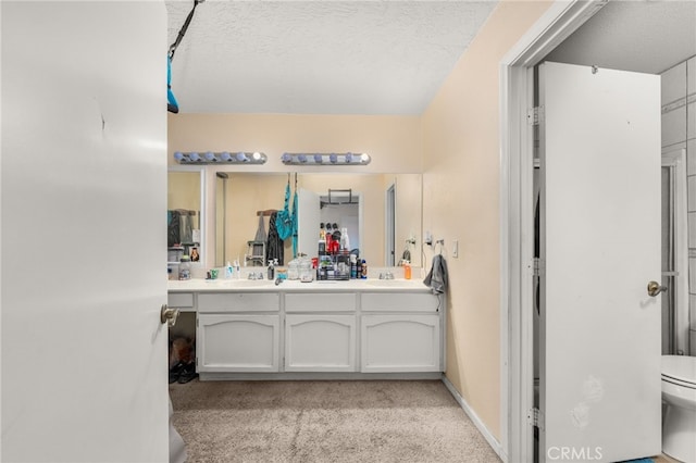 bathroom featuring vanity, a textured ceiling, and toilet