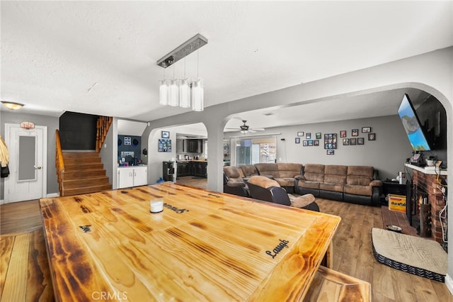 dining room featuring a textured ceiling, hardwood / wood-style flooring, and ceiling fan