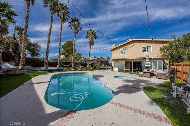 view of swimming pool featuring an in ground hot tub, a yard, a patio, and a sunroom