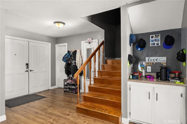 foyer entrance featuring a textured ceiling and light wood-type flooring