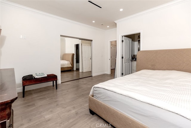 bedroom with light hardwood / wood-style flooring, a closet, and crown molding