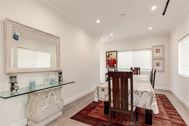 dining space with light wood-type flooring and ornamental molding