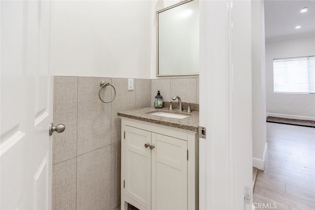 bathroom featuring vanity, hardwood / wood-style flooring, and tile walls