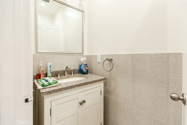 bathroom with vanity and tile walls