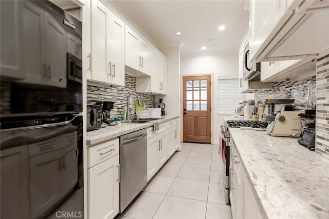 kitchen with decorative backsplash, light stone countertops, and appliances with stainless steel finishes