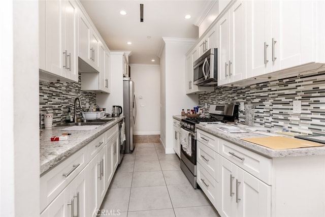 kitchen with sink, crown molding, decorative backsplash, white cabinetry, and stainless steel appliances