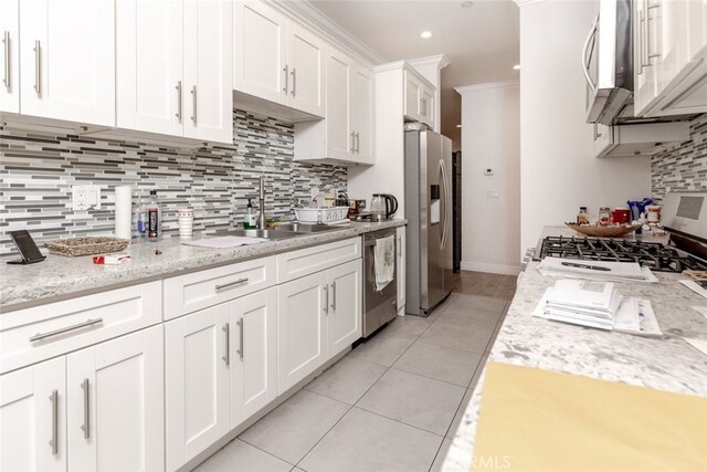 kitchen with white cabinets, crown molding, sink, decorative backsplash, and stainless steel appliances