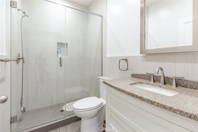 bathroom featuring vanity, toilet, and an enclosed shower