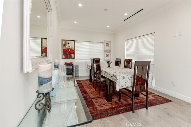 dining room featuring crown molding and light hardwood / wood-style flooring