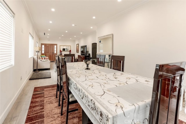 dining room featuring light hardwood / wood-style floors and crown molding