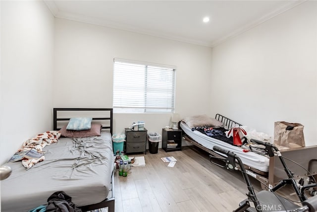 bedroom with light wood-type flooring and ornamental molding