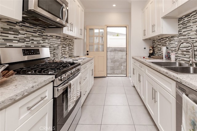 kitchen featuring white cabinetry, sink, light stone counters, and appliances with stainless steel finishes