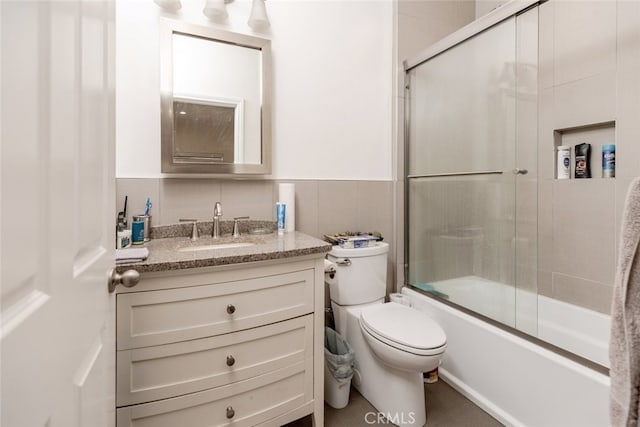 full bathroom with vanity, toilet, and bath / shower combo with glass door