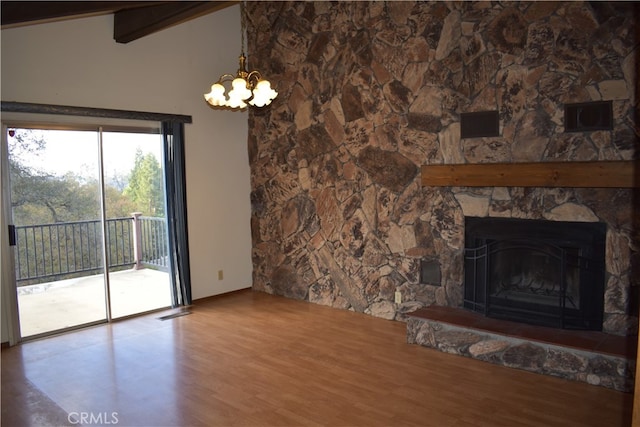 unfurnished living room featuring beam ceiling, a chandelier, wood-type flooring, and a fireplace