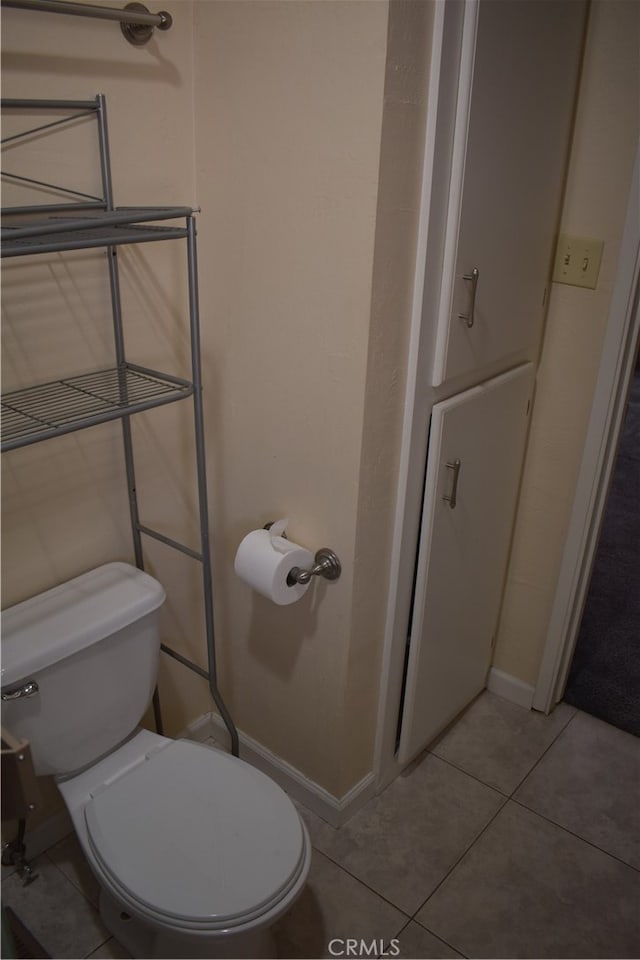 bathroom with toilet and tile patterned flooring