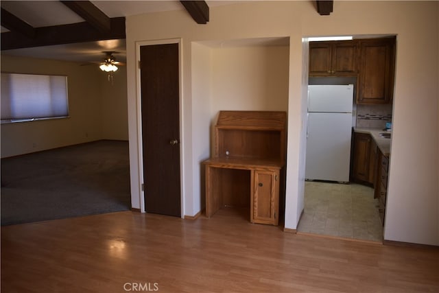 kitchen with beam ceiling, white refrigerator, light hardwood / wood-style floors, and ceiling fan