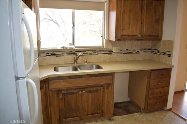 kitchen with sink, backsplash, and white refrigerator