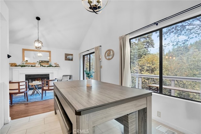 dining room with vaulted ceiling, a notable chandelier, and light wood-type flooring